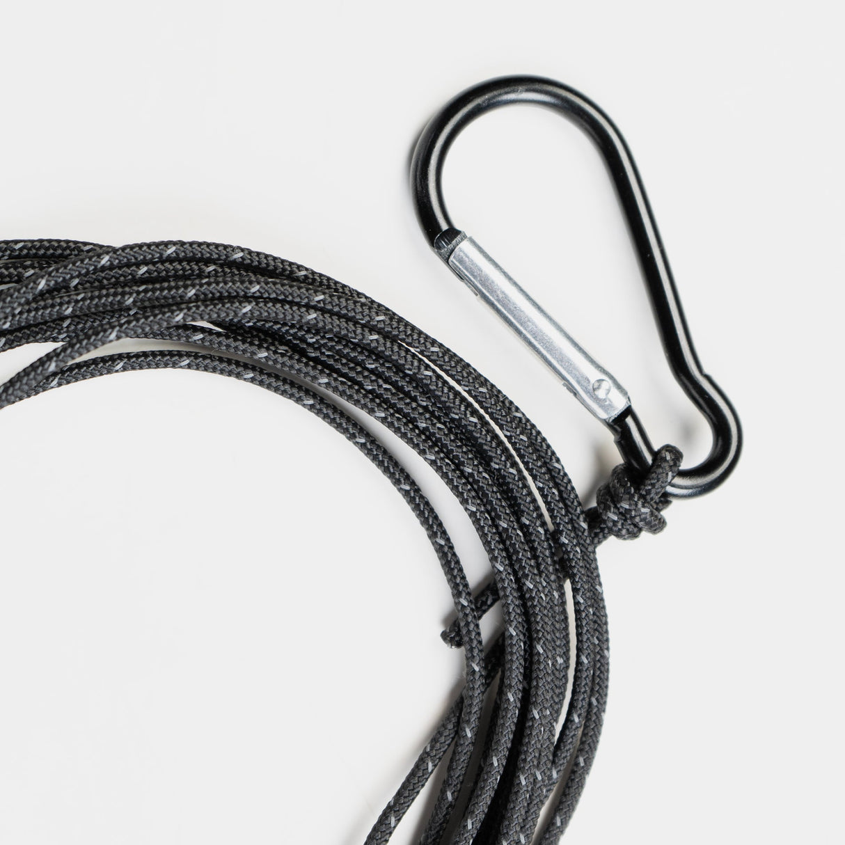 Schwarze, geflochtene Schnur mit einem Karabinerhaken, gelegentlich für Outdoor-Aktivitäten verwendet.