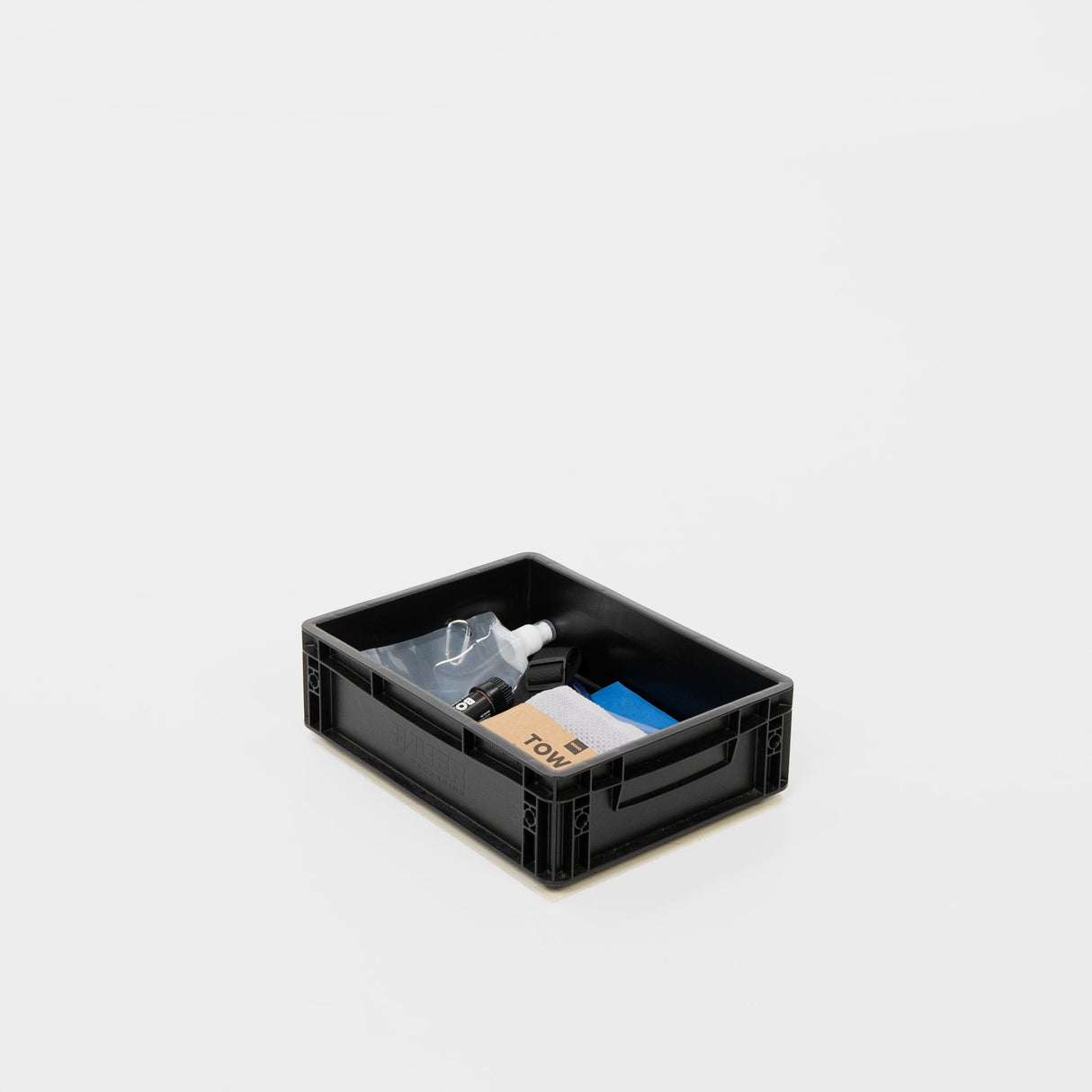 Schwarze Aufbewahrungsbox mit Reinigungsutensilien wie Sprühflasche, Tuch und Putzmaterialien.