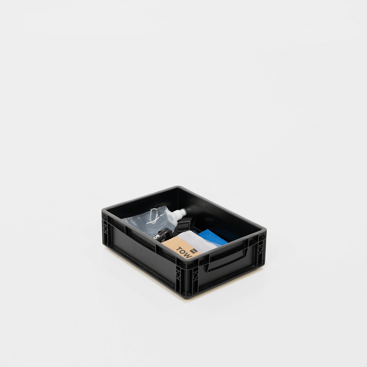 Schwarze Aufbewahrungsbox mit verschiedenen Reinigungsutensilien, darunter eine Sprühflasche, Tücher und Zubehör.
