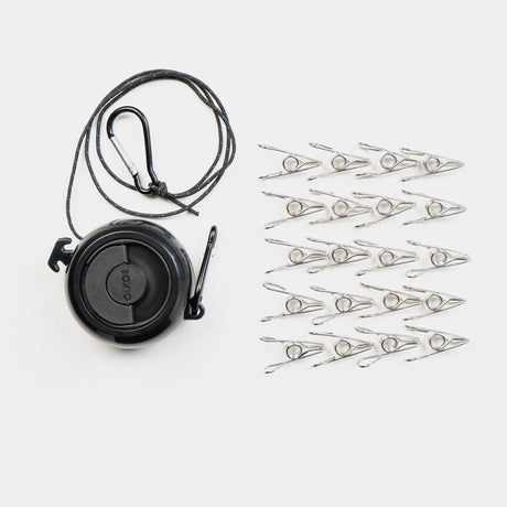 Schwarze Schnurrrolle mit Karabiner und 20 silbernen Wäscheklammern auf weißem Hintergrund.