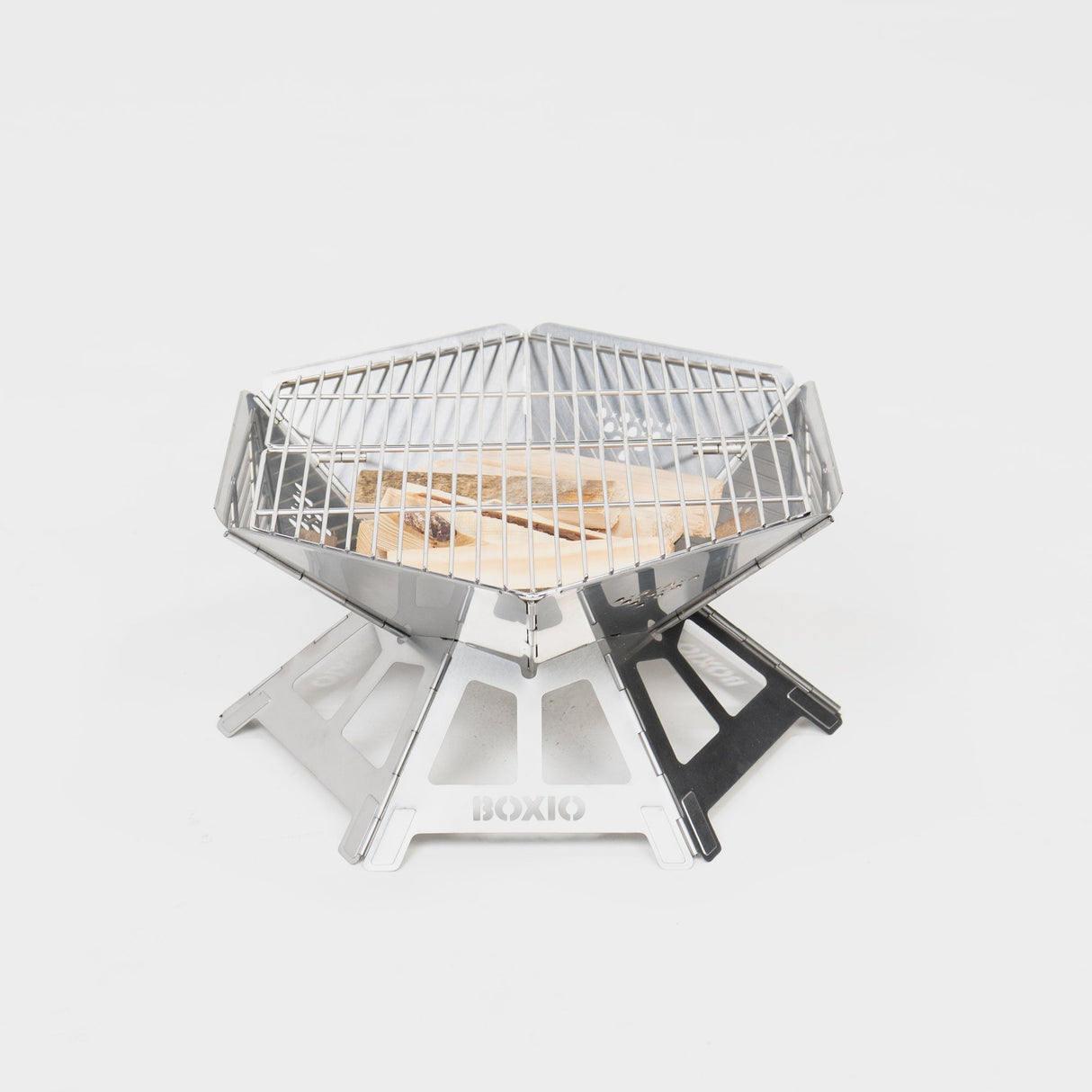 Sternförmiger Portable Grill aus Edelstahl mit Holzscheiten im Inneren, ideal für Camping und Outdoor-Aktivitäten.