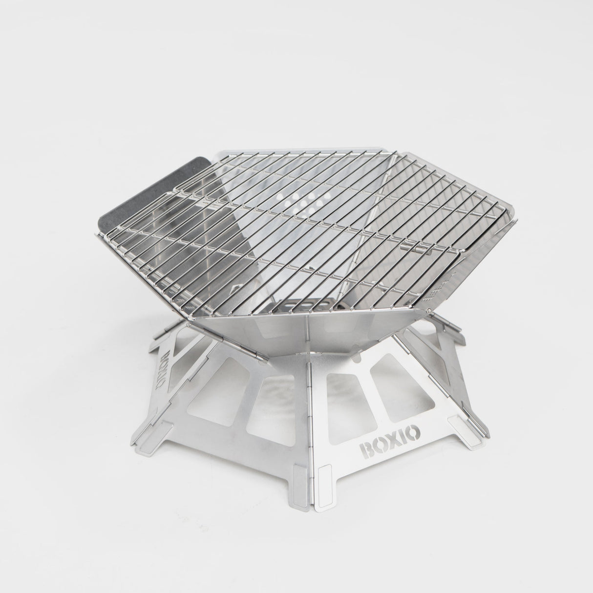 Kompakter, tragbarer Edelstahl-Grill mit hexagonaler Form und stabiler Unterkonstruktion. Ideal für Outdoor-Aktivitäten.