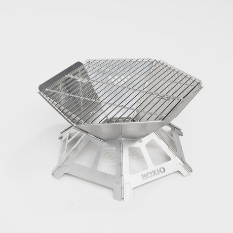 Kompakter, tragbarer Edelstahl-Grill mit hexagonaler Form und stabiler Unterkonstruktion. Ideal für Outdoor-Aktivitäten.