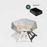 Robuster Edelstahl-Grill mit Holzkohleschicht und Grillrost, daneben schwarzer Aufbewahrungskasten.