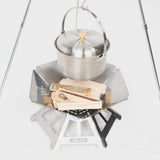 Edelstahl-Kochtopf auf einem stabilen Kocher mit Holzscheiten, ideal für Grillen und Camping.