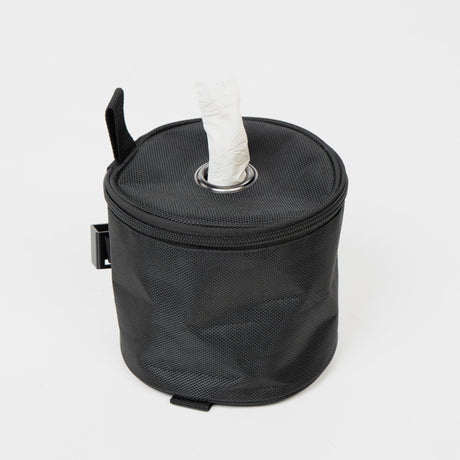 Schwarze, runde Tasche mit offenem Deckel und Papiertaschentuch, ideal für unterwegs und praktische Aufbewahrung.