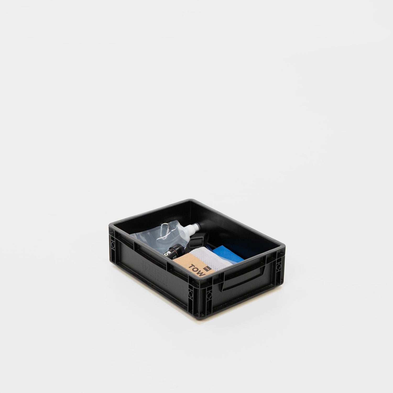 Schwarze Aufbewahrungsbox mit Reinigungsutensilien wie Sprühflasche, Tuch und Putzmaterialien.