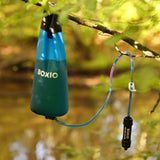 Hängender Wasserfilter von BOXIO an einem Ast, bereit zur Nutzung in der Natur.