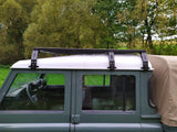 Rolling Space Dachträger, seitlich auf einem grünen Defender mit beigem Planenaufbau